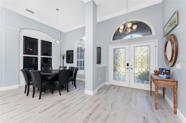 entryway featuring a notable chandelier, visible vents, french doors, light wood finished floors, and crown molding