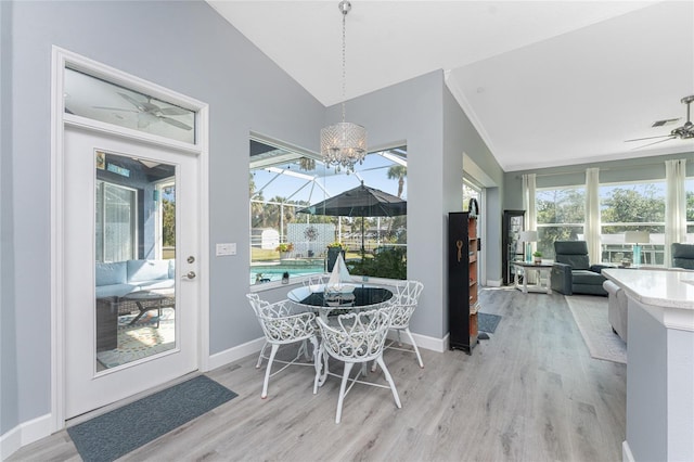 dining area with a sunroom, vaulted ceiling, a ceiling fan, and light wood finished floors