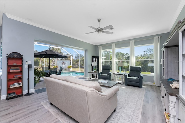 living area with ornamental molding, ceiling fan, light wood-style flooring, and a sunroom