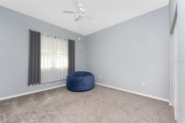 interior space featuring lofted ceiling, carpet, baseboards, and a ceiling fan