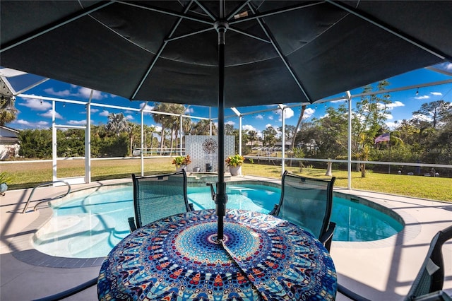 view of swimming pool featuring a pool with connected hot tub, a lanai, and a lawn