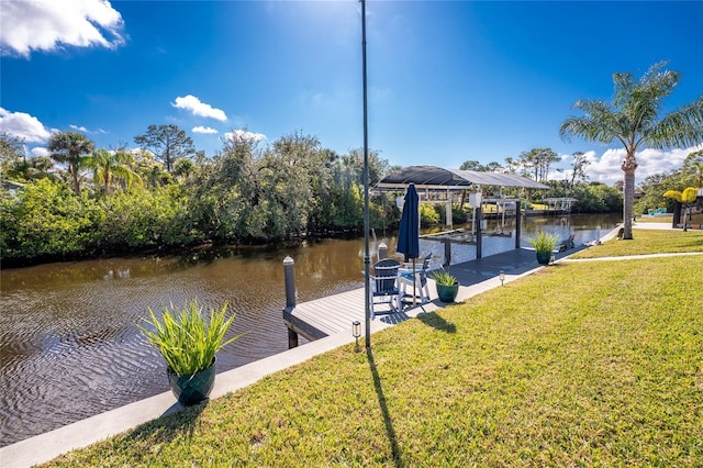 dock area featuring a water view, boat lift, and a lawn