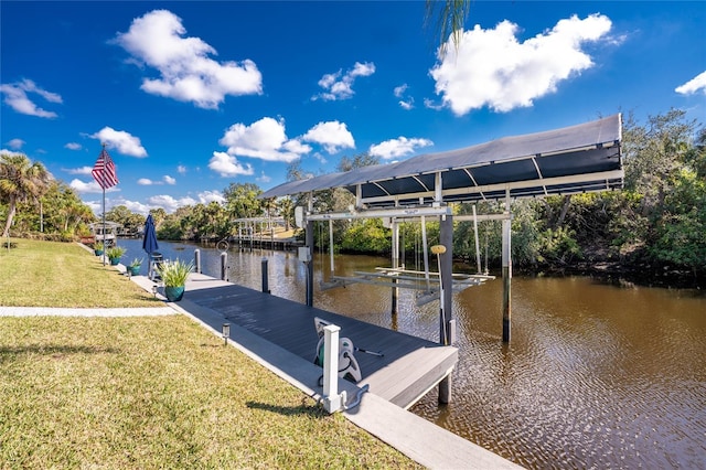 dock area with a yard, a water view, and boat lift