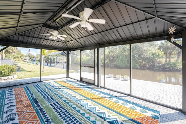 unfurnished sunroom with a ceiling fan, lofted ceiling, and a water view