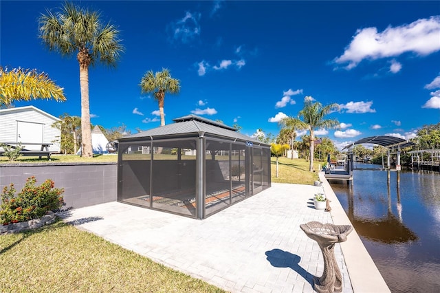 exterior space featuring a patio area, a water view, and a lawn