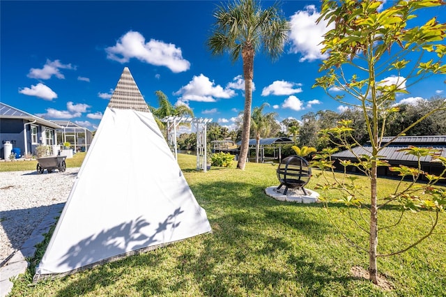 view of property's community with a fire pit and a yard