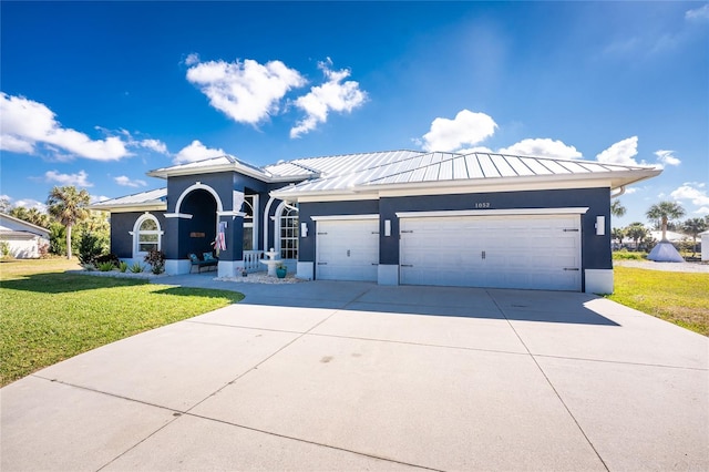 ranch-style house with metal roof, a standing seam roof, an attached garage, and stucco siding