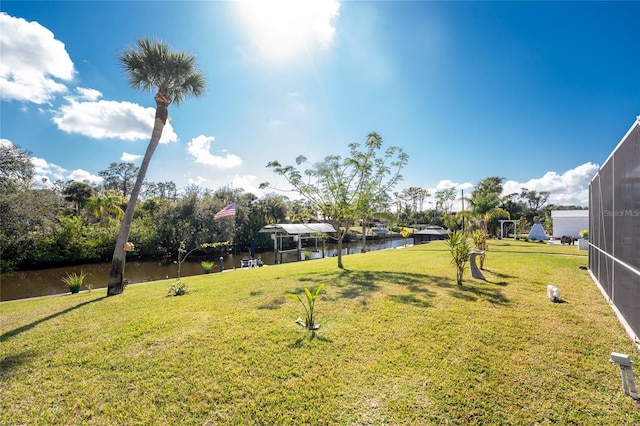 view of yard featuring a lanai and a water view