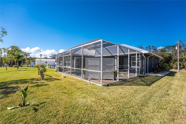 back of house featuring glass enclosure, an outdoor pool, and a lawn