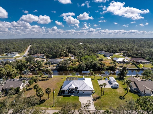 aerial view with a forest view, a water view, and a residential view