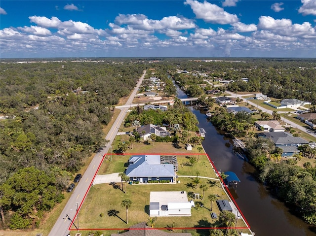 drone / aerial view with a water view, a wooded view, and a residential view