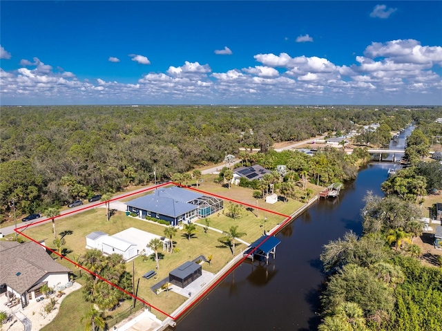 birds eye view of property featuring a water view and a view of trees