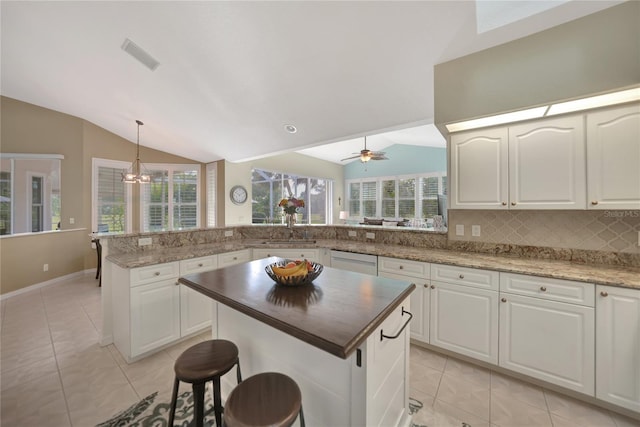 kitchen featuring white cabinetry, decorative light fixtures, kitchen peninsula, and a kitchen island