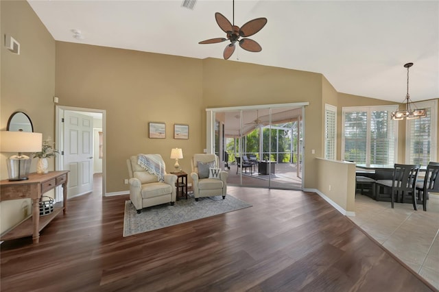 sitting room with ceiling fan with notable chandelier, high vaulted ceiling, and light hardwood / wood-style floors