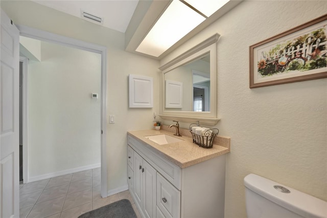 bathroom with vanity, tile patterned floors, and toilet