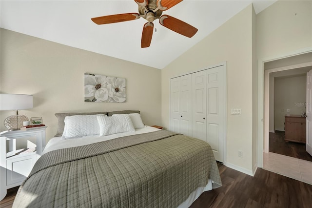 bedroom featuring dark wood-type flooring, vaulted ceiling, a closet, and ceiling fan