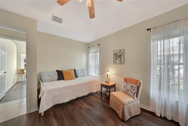 bedroom with multiple windows, dark hardwood / wood-style floors, and ceiling fan