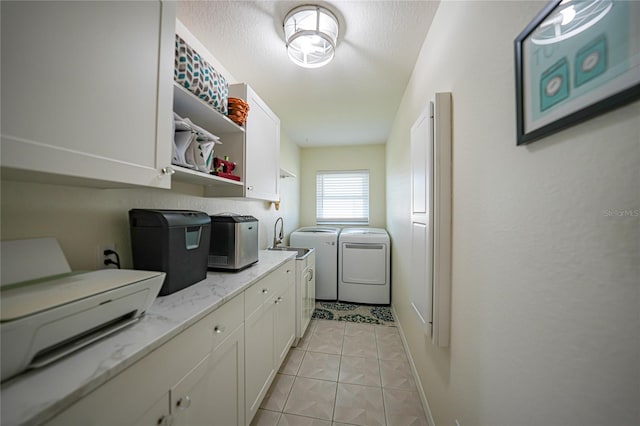 laundry area with washing machine and dryer, a textured ceiling, and light tile patterned floors