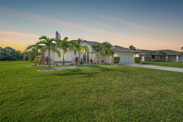 single story home with a garage and a yard