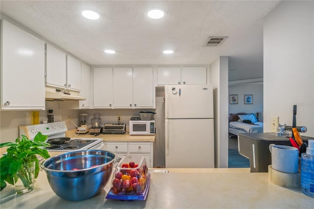 kitchen with a textured ceiling, white cabinets, and white appliances