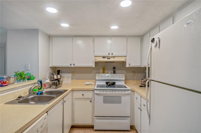 kitchen with sink, white cabinets, white appliances, light tile patterned floors, and a textured ceiling