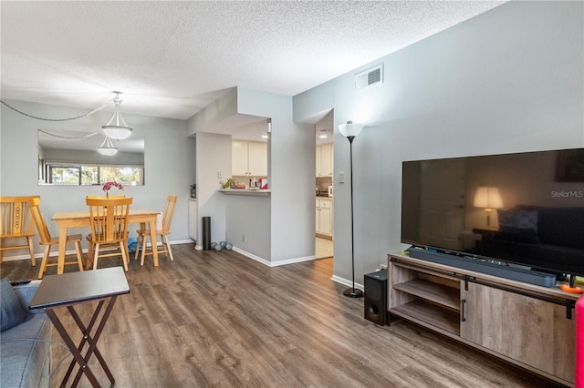 dining space with hardwood / wood-style flooring and a textured ceiling