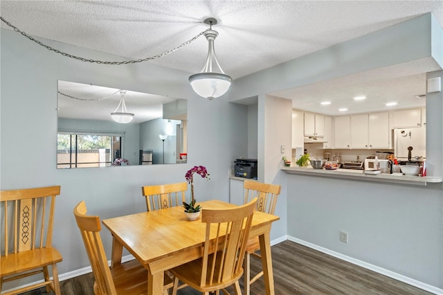 dining area featuring dark hardwood / wood-style floors and a textured ceiling