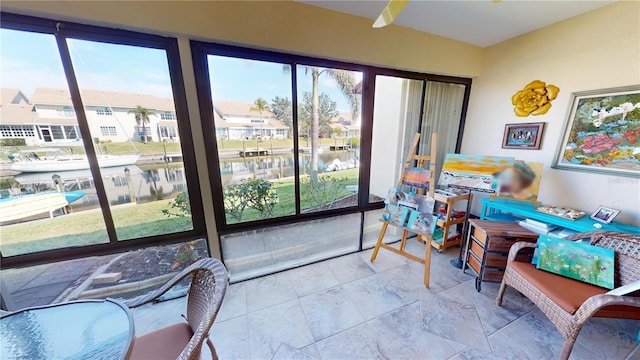 sunroom featuring a water view