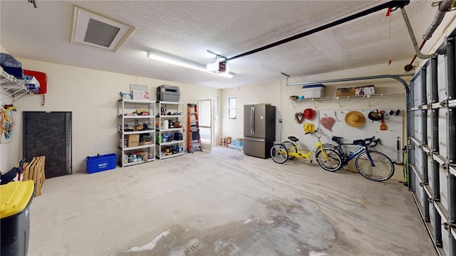 garage featuring a garage door opener and stainless steel refrigerator