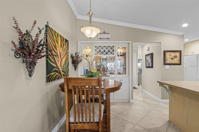 tiled dining space featuring ornamental molding and bar area