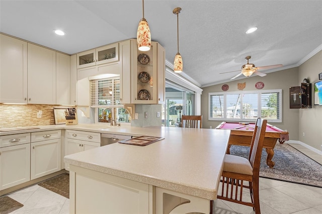 kitchen with sink, decorative light fixtures, vaulted ceiling, a kitchen breakfast bar, and decorative backsplash