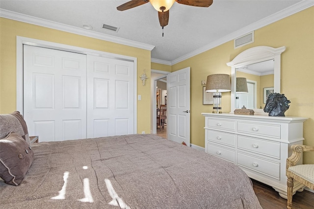 bedroom with crown molding, dark hardwood / wood-style floors, a closet, and ceiling fan