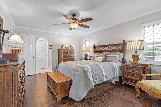 bedroom featuring dark wood-type flooring, ornamental molding, and ceiling fan