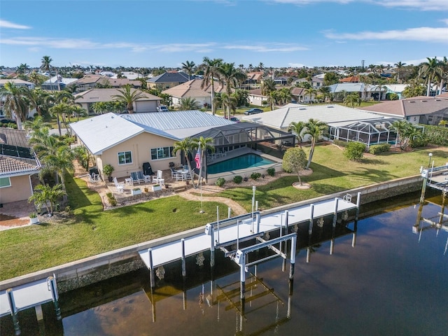 exterior space with a patio, a yard, glass enclosure, a fenced in pool, and a water view