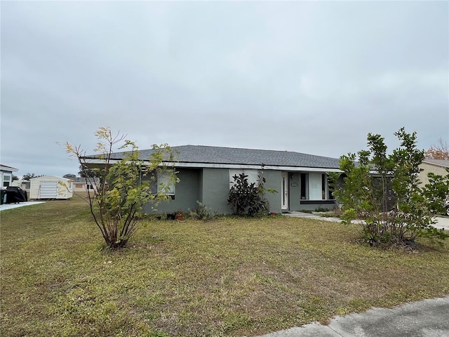 view of front of home featuring a front yard and stucco siding