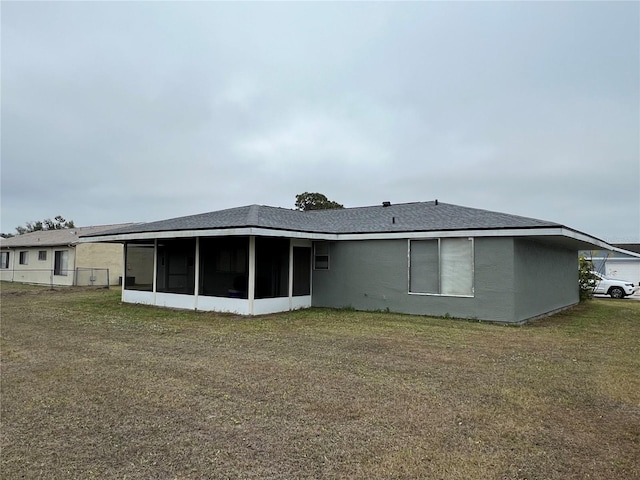 back of house with a lawn and a sunroom