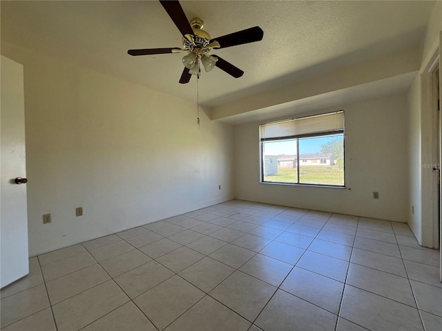 spare room with light tile patterned flooring, ceiling fan, and a textured ceiling