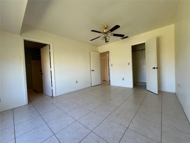 unfurnished bedroom featuring a closet, visible vents, ceiling fan, and light tile patterned floors