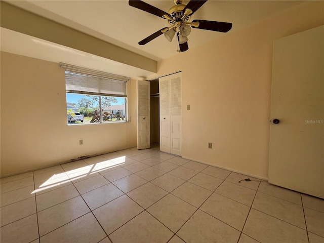 unfurnished bedroom featuring a closet, ceiling fan, and light tile patterned floors