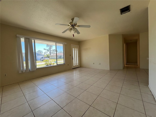 unfurnished room featuring ceiling fan, a textured ceiling, light tile patterned flooring, and visible vents