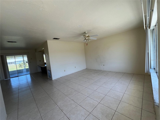 empty room with a ceiling fan, visible vents, and light tile patterned floors