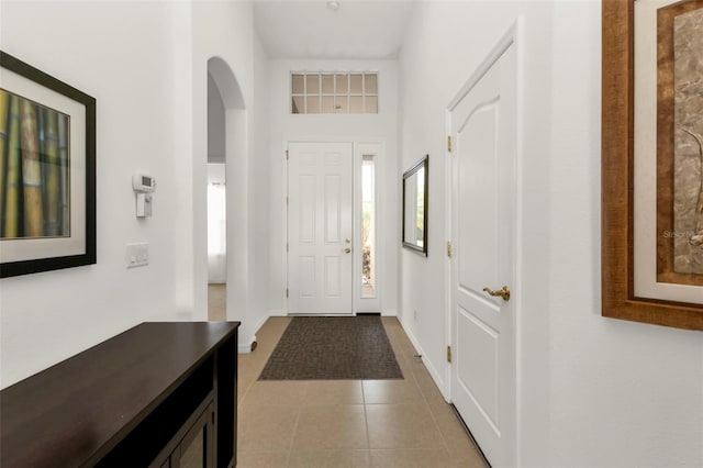 foyer entrance with a towering ceiling and light tile patterned floors