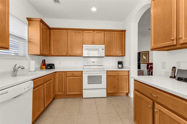 kitchen featuring white appliances, sink, and light tile patterned floors