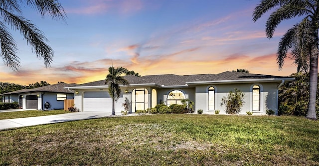 ranch-style house featuring a garage and a lawn