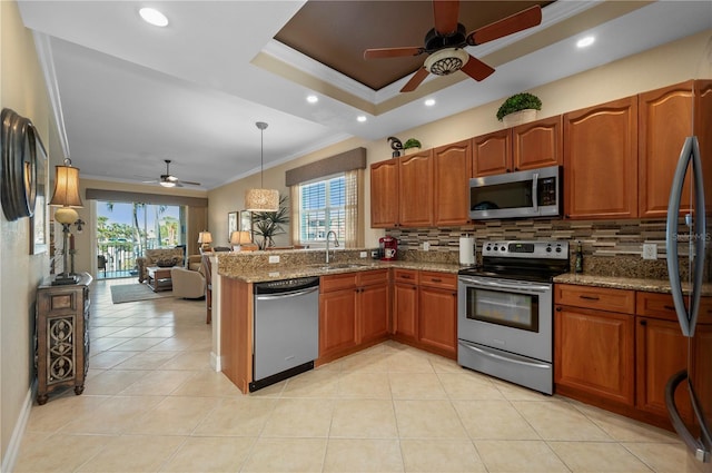 kitchen with stone counters, appliances with stainless steel finishes, hanging light fixtures, ornamental molding, and decorative backsplash