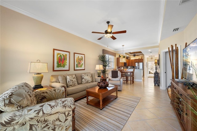 living room with light tile patterned floors, ornamental molding, and ceiling fan