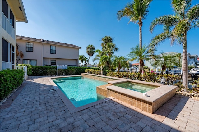 view of pool featuring an in ground hot tub