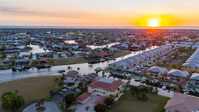 aerial view at dusk featuring a water view