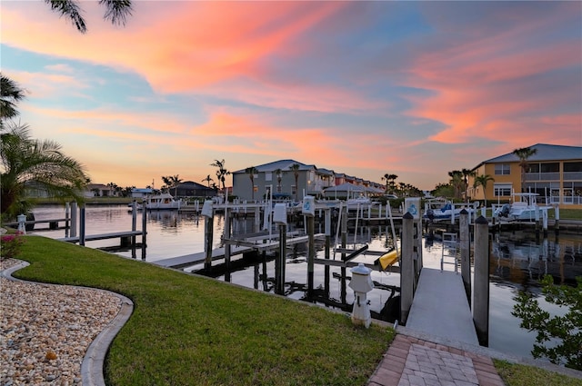 dock area with a lawn and a water view