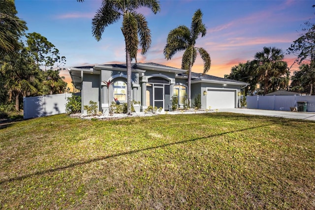 view of front of home with a garage and a yard